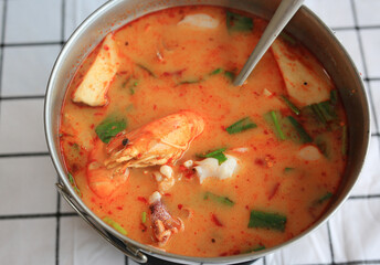 Prawn Tom yum soup in aluminium pot on the table. Traditional thai style food hot and spicy call 