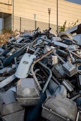 Photo from low angle shows a skip bin loaded with old technology street lamps, ready to go for recycling. 