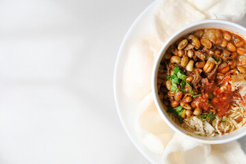 Chicken porridge or bubur ayam with various toppings and crackers