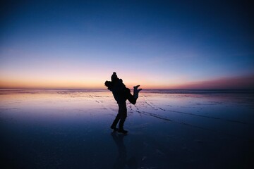 ボリビア、ウユニ塩湖で抱き合うカップルのシルエット