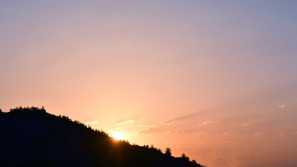 Sunrise shining through the mountain. Golden yellow orange blue sky and cloud in the morning. Beautiful nature in countryside. Sunset sky.
