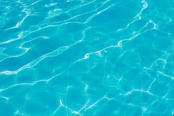 Blue water with ripples on the surface. Defocused, blurred, transparent, blue, clean, calm water surface texture. 