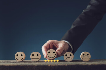 customer services best excellent business rating experience. Satisfaction survey concept. Hand of a businessman chooses a smile face on wood block circle. 5 Star Satisfaction.