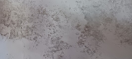 A textured background of peeling white paint and cracks on a wall. This abstract, distressed surface is great for use as a backdrop, or for themes of decay, grunge, and rustic design.