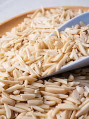 White Almond Stick set on wooden board with versatile scoop and white background.