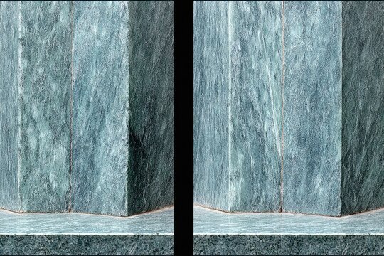Close-up of two matching teal-green stone pillars, showing angled facets and base