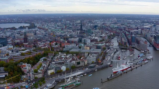 4K drone panorama of Hamburg : Elbe River and Landungsbrucken with Rickmer Rickmers - Cap San Diego, St. Michael&rsquo;s Church, and the canals of Speicherstadt - HafenCity under moody skies.