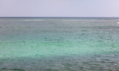 The ocean is calm and clear, with a few small waves in the distance © schankz