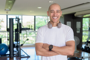 Confident bald Hispanic man posing in gym, fitness and strength-focused lifestyle portrait