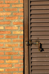 Closed iron gate and a brick wall in a small house in Brazil