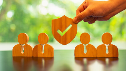 Insurance salesman holding shield symbol with businessman employee model concept of group insurance...