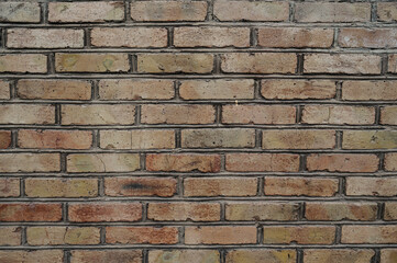 Old weathered brick wall with red and brown bricks
