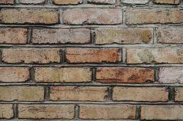 Old weathered brick wall with red and brown bricks