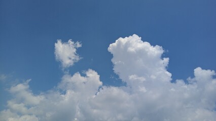 Blue sky with fluffy white clouds, perfect for background.