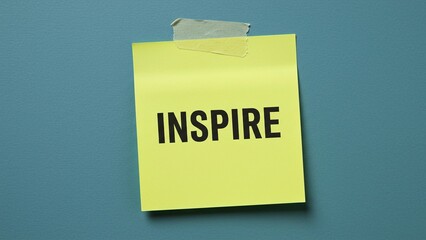 Yellow sticky note with the word "INSPIRE" on a blue background, ideal for motivational content, creative concepts, and personal development