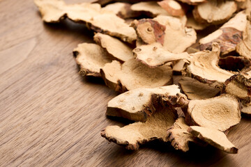 closeup dry galangal root on wood table food background with copy space