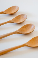 Set of wooden spoons isolated on white background.Natural wooden cooking spoons and ladles with spices placed on white background. Eco-friendly kitchen utensils for cooking.