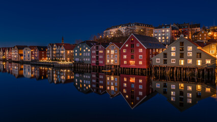 Picturesque Nighttime Reflections of Vibrant Waterside Houses in a Tranquil Scandinavian Harbor