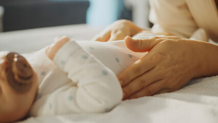 Mother caressing her newborn baby's belly
