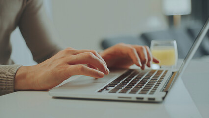 Freelancer working from home typing on laptop in living room