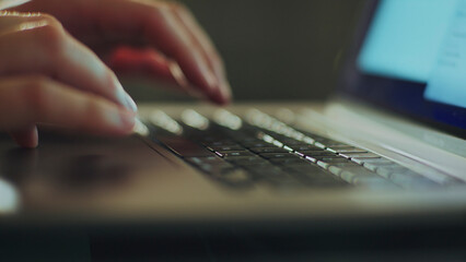 Fototapeta premium Close-up of hands typing on laptop keyboard, working remotely from home office