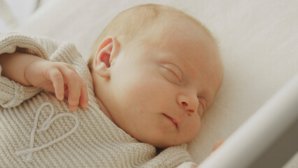 Newborn baby sleeping peacefully in crib wearing knitted clothes