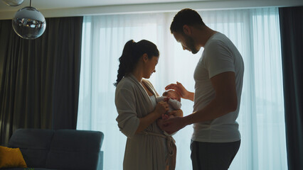 Happy parents holding their newborn baby at home