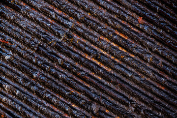 dirty cast iron barbecue grill with burnt food remains on it