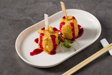Deep-fried corn tempura on sticks with beetroot puree and microgreens