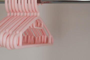 Children's plastic hangers for girls clothes in empty wardrobe