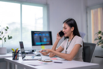 woman is talking on her cell phone while sitting at a desk