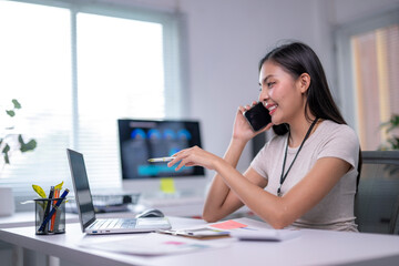 woman is talking on her cell phone while sitting at a desk