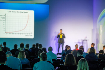 Speaker giving presentation on research and statistics to attentive audience at business event