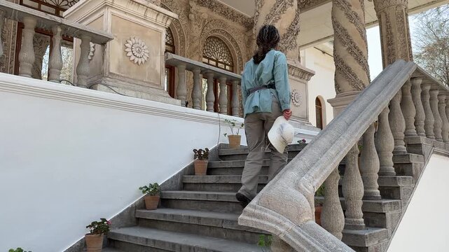 Woman walking upstairs of the Whitehouse Tehran palace Iran landmark Architectural urban landscape city summer attraction Scenic view travel Middle East People entertainment happy outdoor background