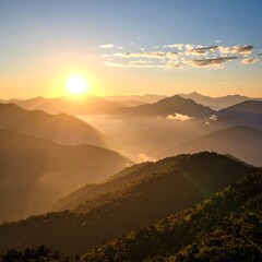 Sunrise over a hazy, mountainous landscape. Golden light bathes rolling hills