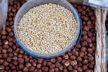 Hazelnuts, pistachios, almonds, cashews, pine nuts and dried fruits in baskets at a farmers market. Sale of nuts. Nuts and dried fruits are used in the preparation of sweet dishes - chocolate, candies