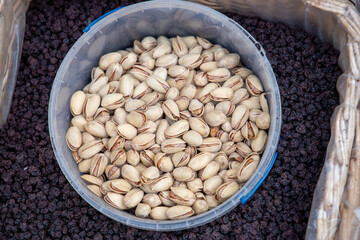 Hazelnuts, pistachios, almonds, cashews, pine nuts and dried fruits in baskets at a farmers market. Sale of nuts. Nuts and dried fruits are used in the preparation of sweet dishes - chocolate, candies