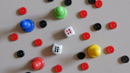 Colorful board game counters and dice on white background.
