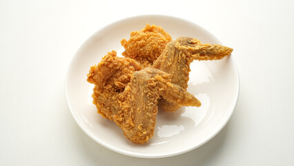 Crispy fried chicken wings on white plate
