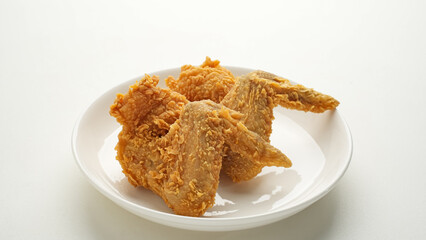 Crispy fried chicken wings on white plate
