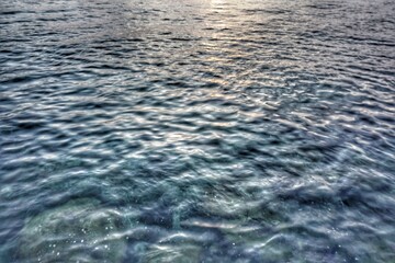 Rippling sea surface with a mix of deep blue and teal hues. Gentle waves create a textured pattern across the water. 