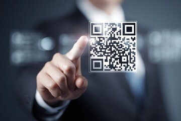 Businessman's finger pointing at a projected QR code