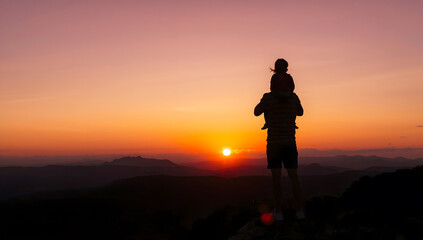 Father and Child Watching the Sunset from a Mountaintop, Silhouette of a Parent and a Child on Shoulders at Dusk