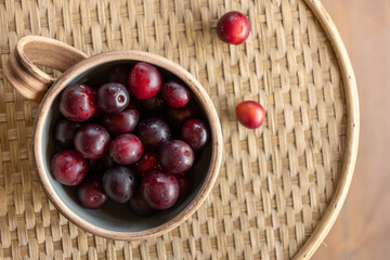 Delicious dark grapes resting in a rustic bowl on a woven tray add a touch of charm to the cozy kitchen setting
