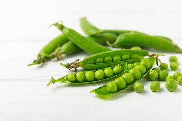 Fresh green pea pods with green peas on a wooden background. Sweet green peas. Green pea beans vegetables. Vegan. healthy vegetable. Copy space