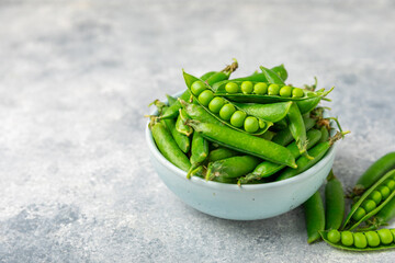 Fresh green pea pods with green peas on a wooden background. Sweet green peas. Green pea beans vegetables. Vegan. healthy vegetable. Copy space