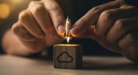 Innovative technology startup launch concept. Hands place a glowing rocket on a wooden block with a cloud computing symbol for business growth