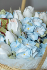 Beautiful arrangement of delicate white and blue flowers in a woven basket, showcasing intricate details and textures, perfect for decorative purposes and floral design inspiration