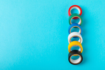 Insulating tape on a bright colored background. Set of different colors insulating tape. Reel insulating tape. Construction tools. Electrician tools. A piece of scotch tape. Space for text.Copy space.
