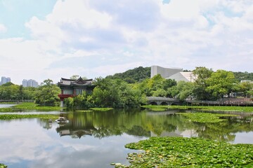 Obraz premium Traditional Korean Pavilion by Lake with Reflections and City Skyline 